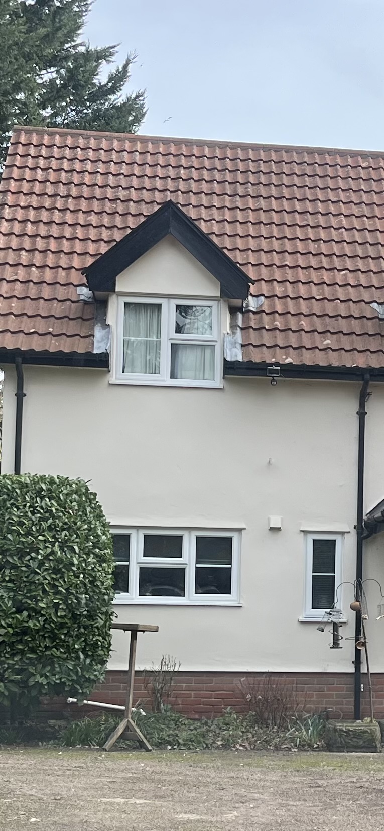 The same dormer roof after cleaning, with brighter red-brown tiles
