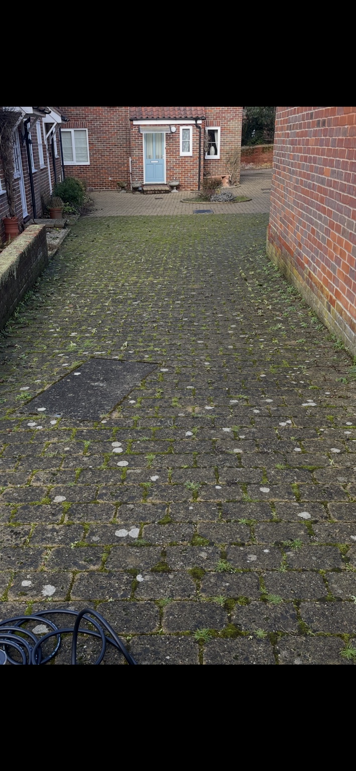 Block paving with moss, weeds and dark surface build-up